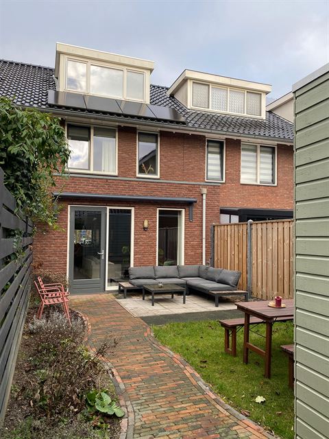 Zicht vanuit de achtertuin op de achtergevel en dakkapel.