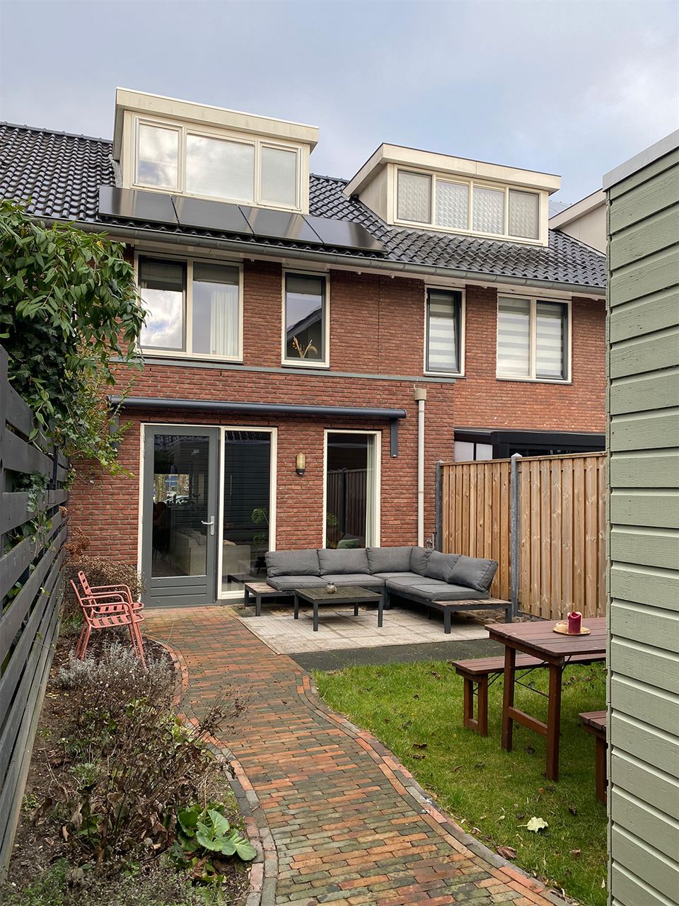 Achtertuin en achtergevel met dakkapel.