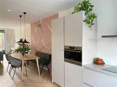 Zicht vanuit de keuken op de eettafel en woonkamer.