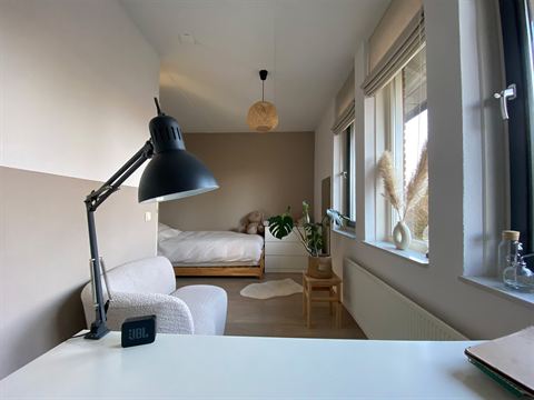 Tweede slaapkamer met bed, bureau en raam aan de voorzijde.