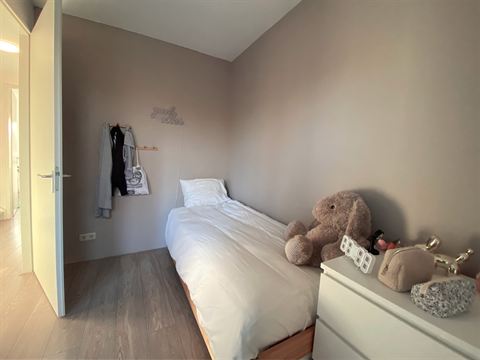 Bed en fauteuil in de tweede slaapkamer.