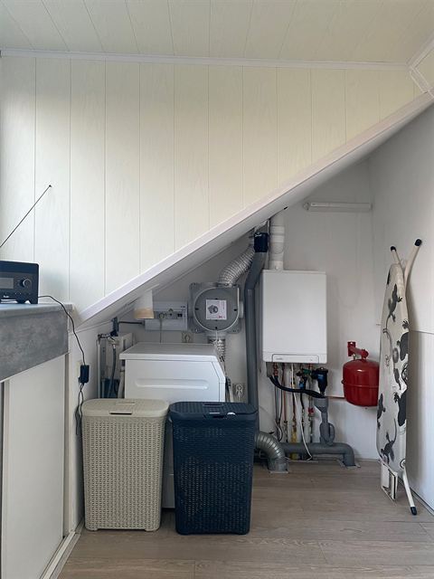 Wasruimte met wasmachine, droger en de cv-installatie op zolder.