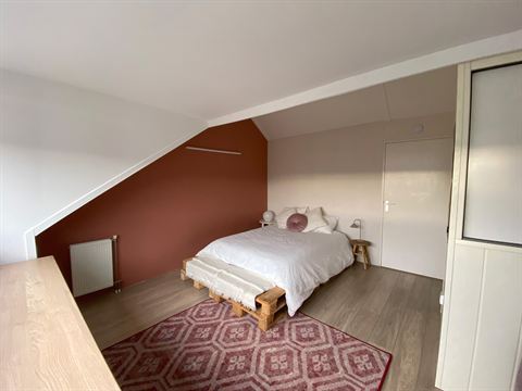 Derde slaapkamer op de tweede verdieping met bed onder het schuine dak.